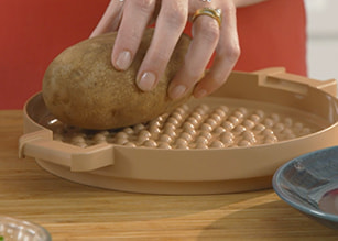 Hand placing potato on base